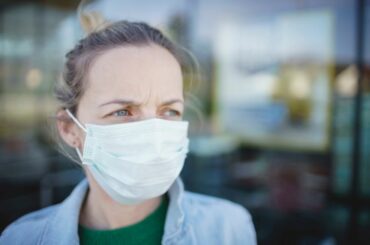 person wearing mask illustrating covid impact